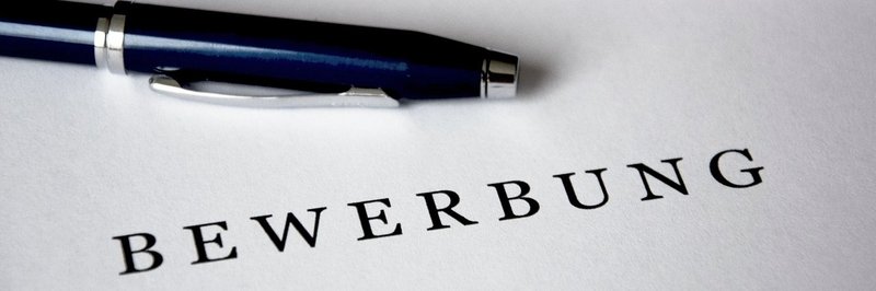 Ein Blatt mit der Beschriftung Bewerbung und ein Kugelschreiber